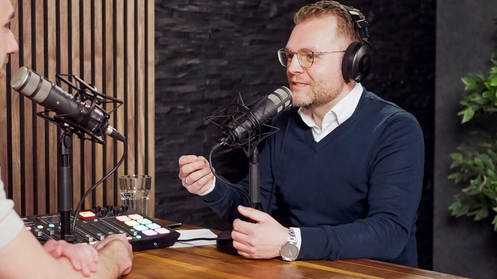 Torsten spricht in ein Mikrofon in einem Podcast-Studio